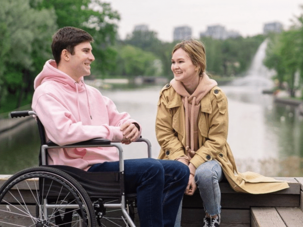 A young man on a wheelchair talkin with a support worker