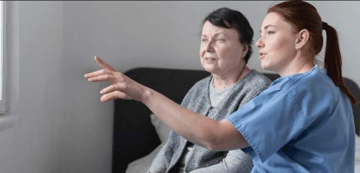 An elderly woman with support worker looking at the window
