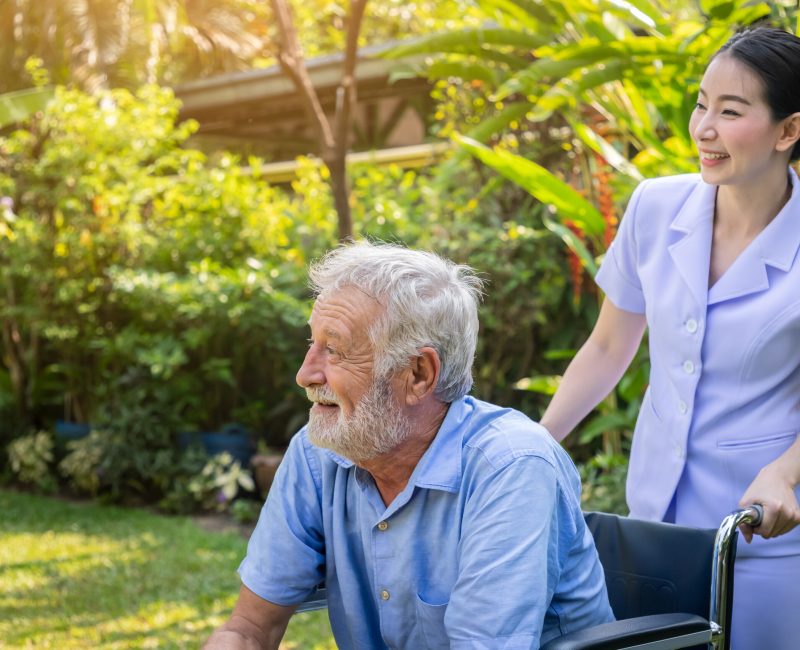 A support worker of nursecare connect taking care of an old man on a wheel chair